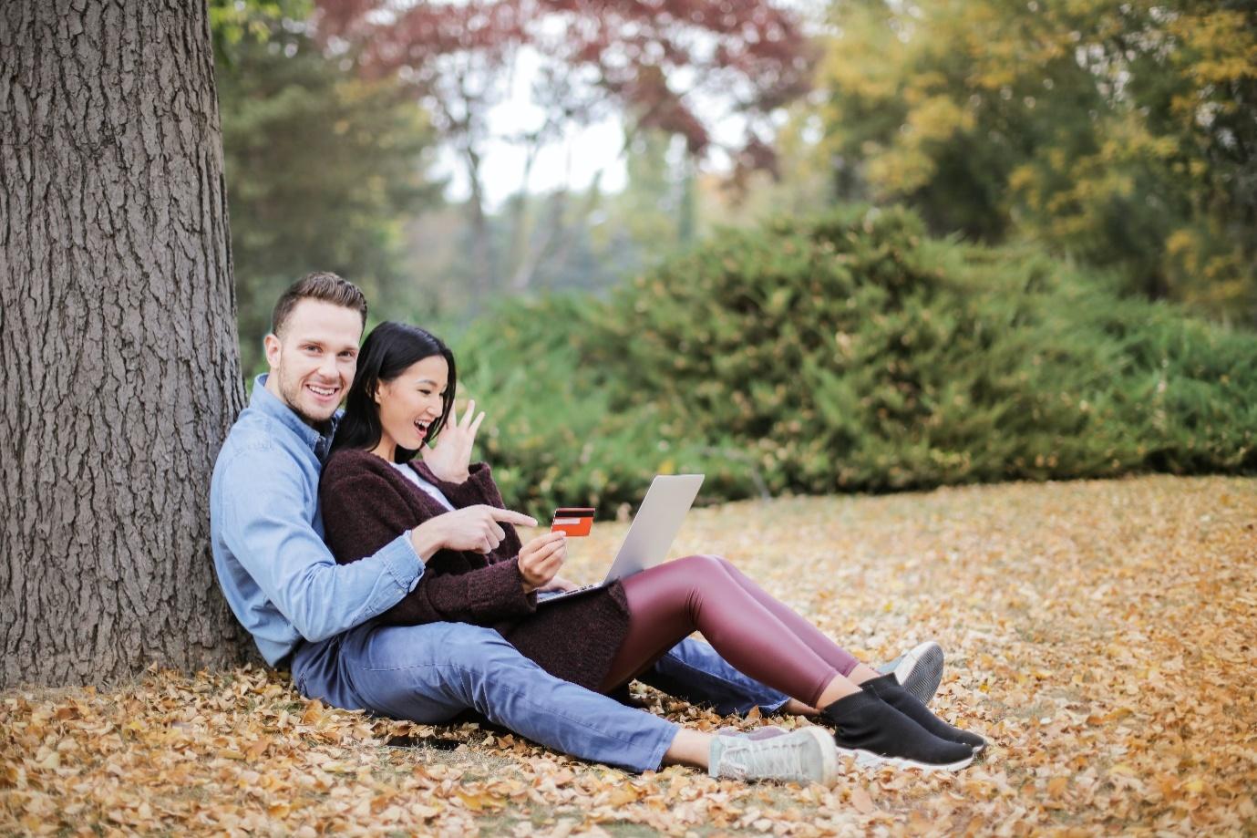 a couple sitting near tree trunks