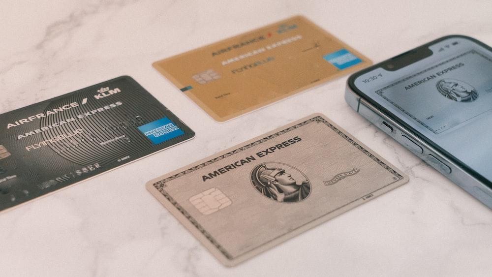 several American Express credit cards next to a phone