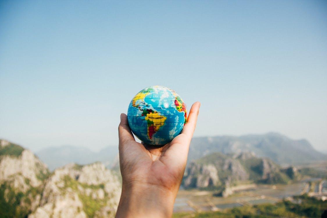 A traveller holding a mini globe