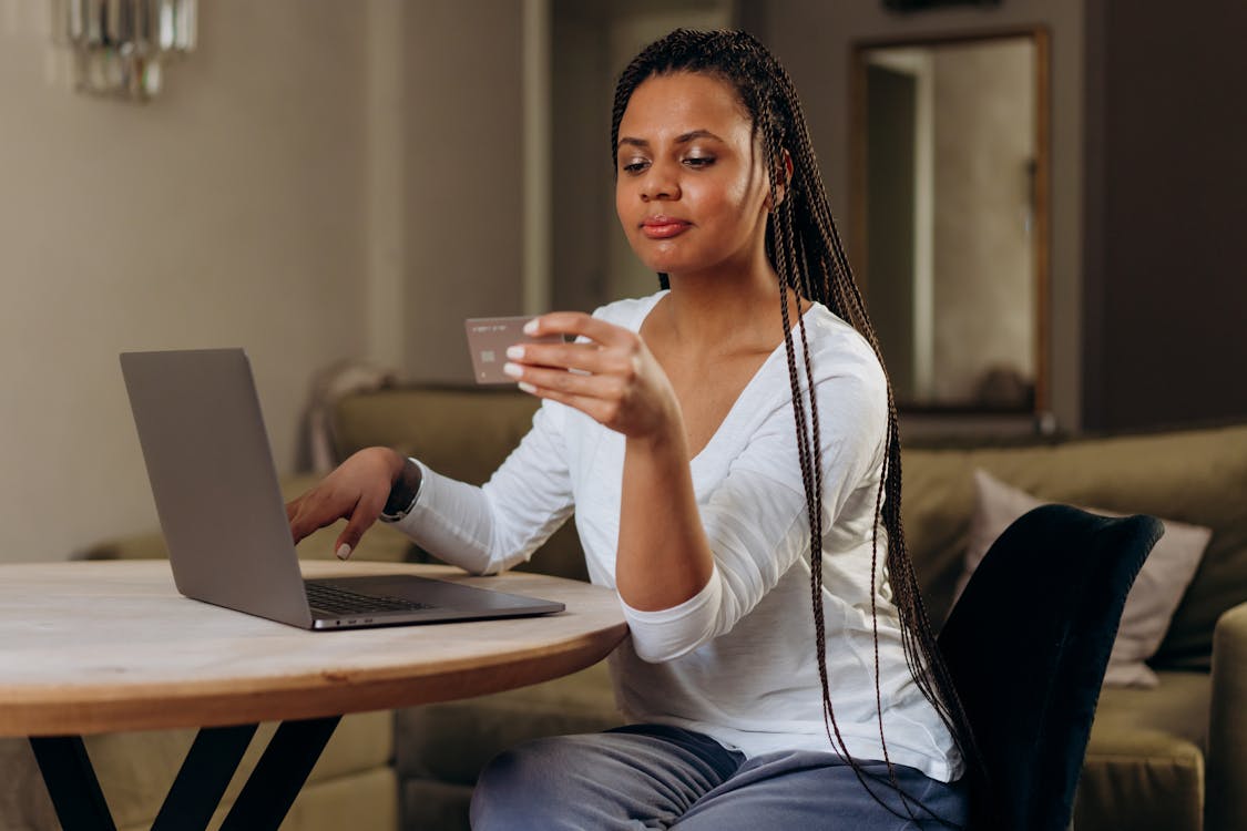 Person holding a credit card with their laptop