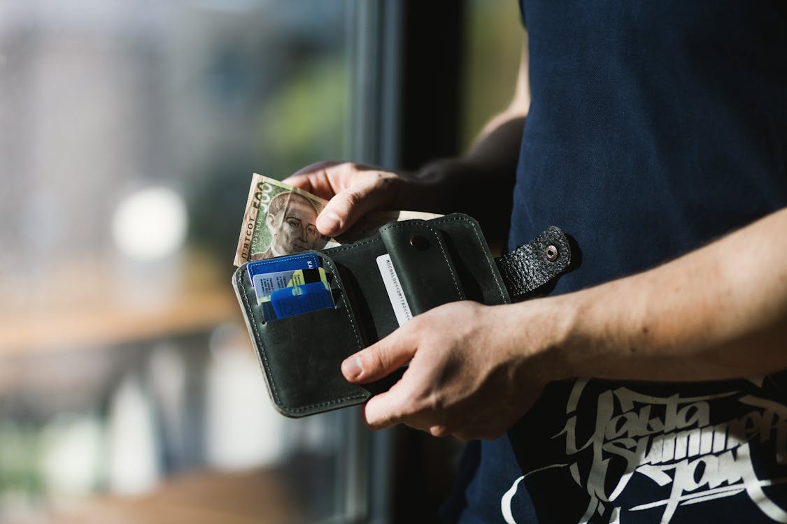 Person keeping money inside their wallet