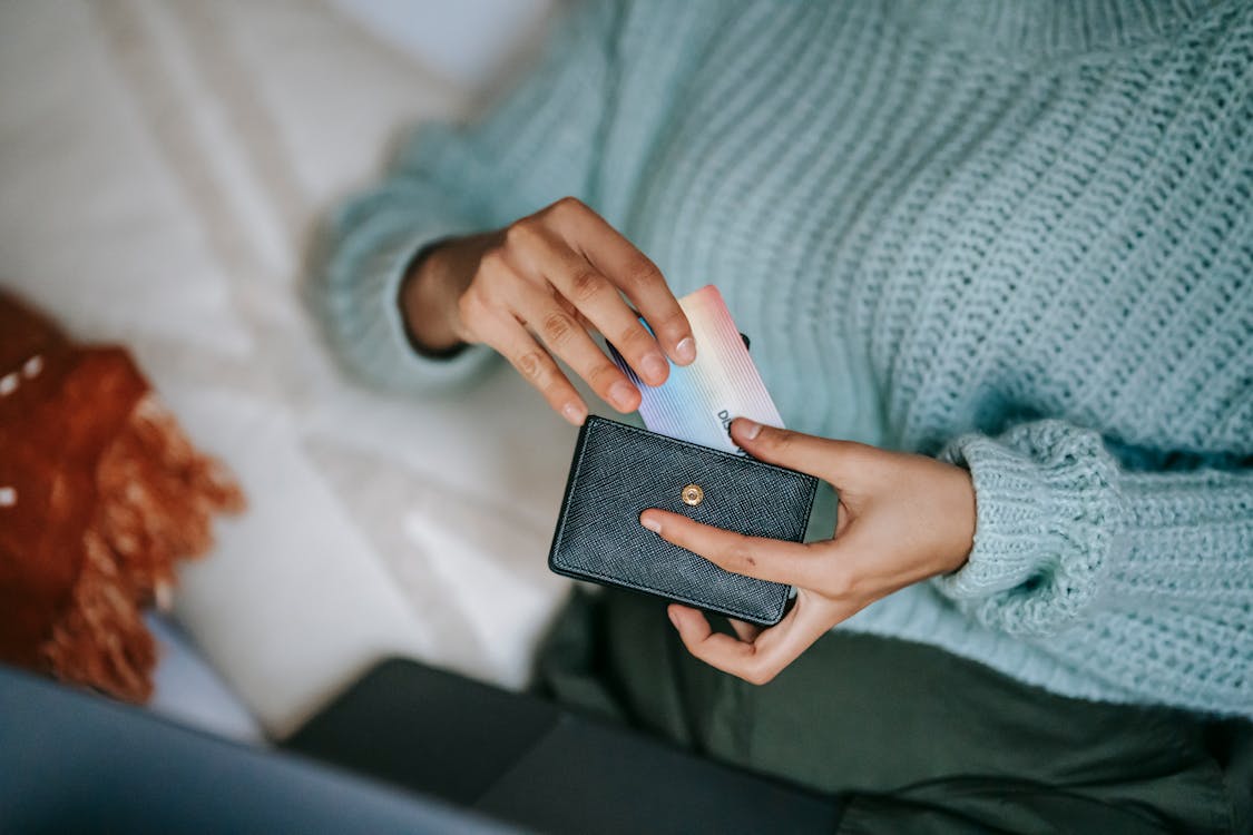 Person putting credit card inside the wallet