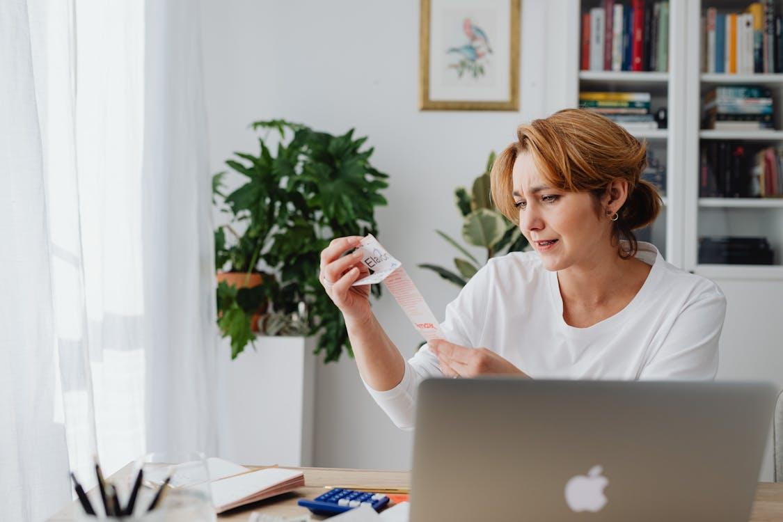 Person sitting behind MacBook reviewing a receipt