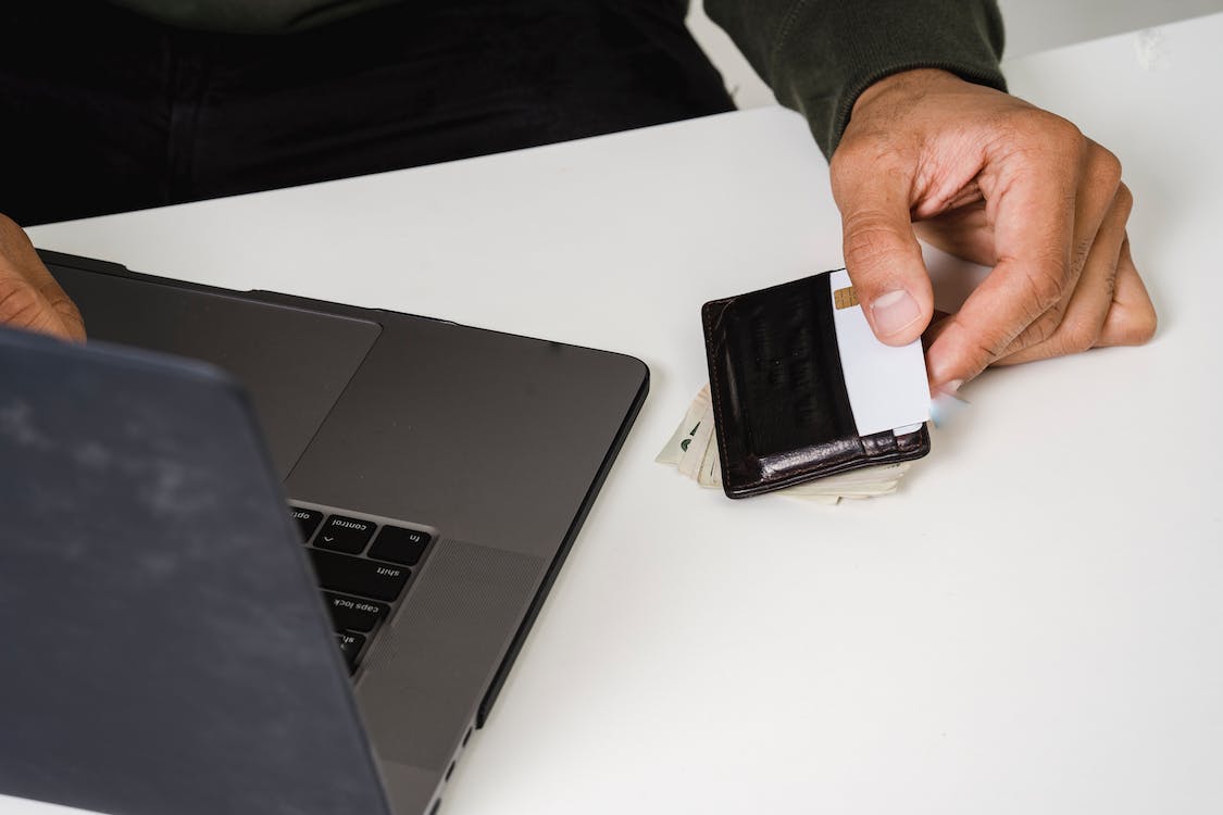 credit card in wallet and laptop on desk