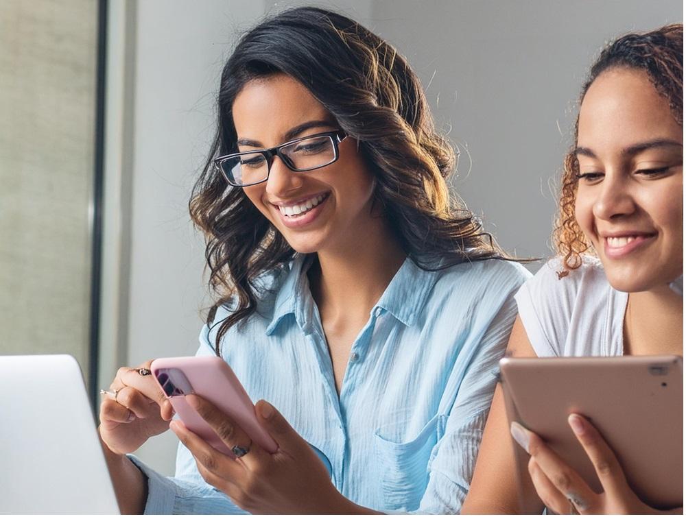 2 women on phones smiling looking to budget
